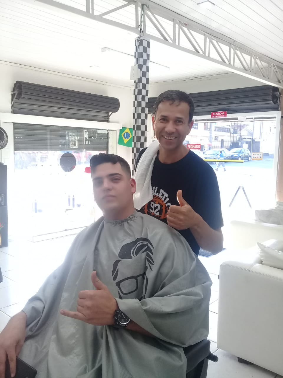 Barbeiro e cliente sorrindo na Barbearia Ponto 47